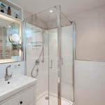 Bathroom with shower, sink, and heated towel rail