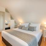 Schlafzimmer mit Dachschrägen, Bett, Nachttisch und Kleiderschrank.