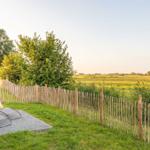 Terrasse mit Liegestühlen und Blick auf grünes Feld