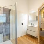 Badezimmer mit Dusche, Waschbecken und Sauna