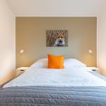 Schlafzimmer mit Bett, Kissen und Wandbild eines Fuchses.