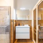 Badezimmer mit Dusche, Waschtisch und Sauna