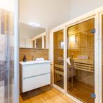 Bad mit Dusche, Waschbecken und Sauna im Holzdesign.