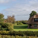 Haus mit Strohdach und Gartenblick auf Wasser
