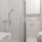 Badezimmer mit Dusche, Toilette und Waschmaschine.
