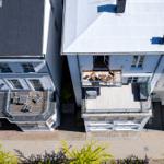 Roof terrace with table and chairs, adjacent buildings with balconies.