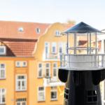 Mini lighthouse on windowsill with view of yellow building
