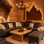 Ein Wohnzimmer mit Holzwand, Ledersofa, Holztisch und Wanddekoration.