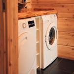 Waschmaschine und Trockner in Holzumgebung mit dunklem Boden