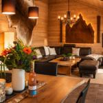 Holzvertäfelte Wohnfläche mit Ledersofa, Holztisch und Wanddekoration.