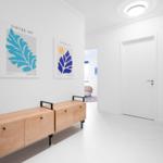 Flur mit Holzschrank und zwei Wandbildern. Tür und Blick in das Schlafzimmer.