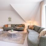 Wohnzimmer mit zwei Sofas, Tisch und Fenster zur Aussicht.