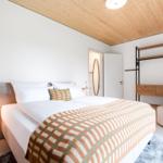 Schlafzimmer mit Doppelbett, Holzdecke und Kleiderständer