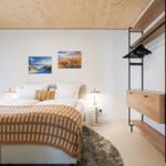 Schlafzimmer mit Bett, Kleiderschrank und Wandbildern