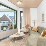Wohnzimmer mit Sofa, Couchtisch und Blick auf Balkon