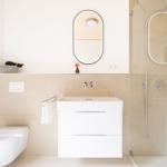 Badezimmer mit Dusche, Waschbecken und Toilette. Moderne Einrichtung und hellen Farben.