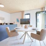 Küche und Essbereich mit runden Tisch, Stühlen und Glasfront zur Terrasse.