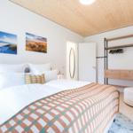 Schlafzimmer mit Bett, Kleiderschrank und Wandbildern