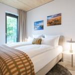 Schlafzimmer mit Doppelbett, Fenster und Wandbildern