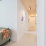 Wohnbereich mit Sofa und Flur mit Holzdecke und Wandbildern.