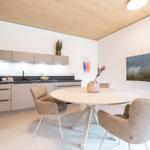 Küche mit Essbereich, runder Tisch und Stühle, Fernseher an der Wand.