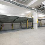 Automatisches Parkhaus mit mehreren Stellplätzen und gelben Sicherheitsgeländern.