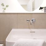 Waschbecken mit Wasserhahn, Spiegelfläche und Handtuch
