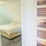 Schlafzimmer mit Bett, Kleiderschrank und Tür mit Nummer 5