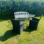 Outdoor area with round table and four chairs on grass