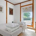 Bedroom with bed, window, and wooden furniture.