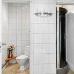 Bathroom with toilet, shower, and hooks on the wall.