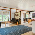 Living and dining area with seating, table, rug, and windows to the outside.