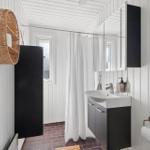 Bathroom with sink, shower curtain, and wooden door.