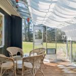 Terrace with rattan furniture, glass front, and white roof