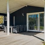 Deck with table, chairs, and grill under roof