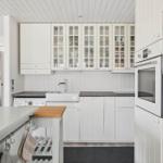 Kitchen with white cabinets, countertop, and sink. Includes dishwasher and refrigerator.