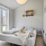 Bedroom with bed, window, and wood paneling.