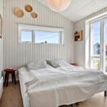 Bedroom with bed, window, and glass door to outdoor terrace.