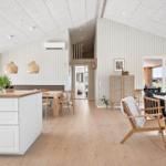 Living and dining area with wooden floor, white walls, and modern furniture.