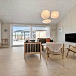 Living room with wooden floor, seating, and TV. Access to terrace.