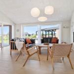 Living room with sofa, chairs, and TV. Doorways to terrace and garden.