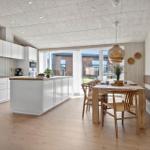 Kitchen with dining area, wooden floor, and windows to the garden.