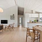 Living and dining area with wooden floor, white walls, and kitchen island.