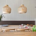 Dining room with wooden table, bamboo lamps, and plants.