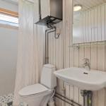 Bathroom with toilet, sink, and shower with curtain.