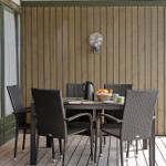 Terrace with table and four chairs, wooden wall and garden door.