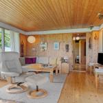 Living room with wooden ceiling, sofa, recliner, and view of field.