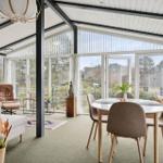Grosses Esszimmer mit Tisch und Stühlen. Durchgehendes Fenster zur Außenseite.