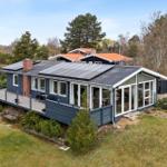 Ein modernes Haus mit Solaranlage und großem Balkon im Grünen.