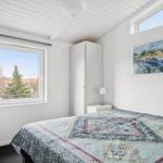 Schlafzimmer mit Bett, Fenster und Gemälde an der Wand.